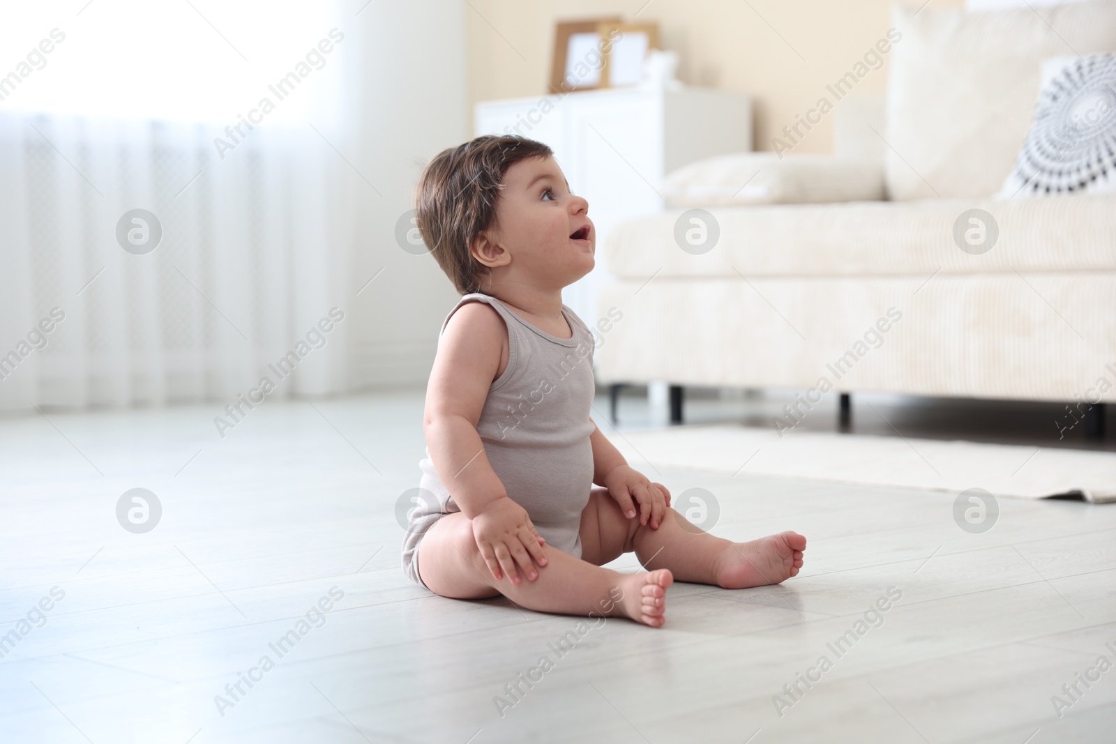 Cute little baby sitting on floor at home Photo of Cute little baby sitting on floor at home