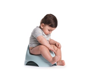 Photo of Cute little baby sitting on potty against white background
