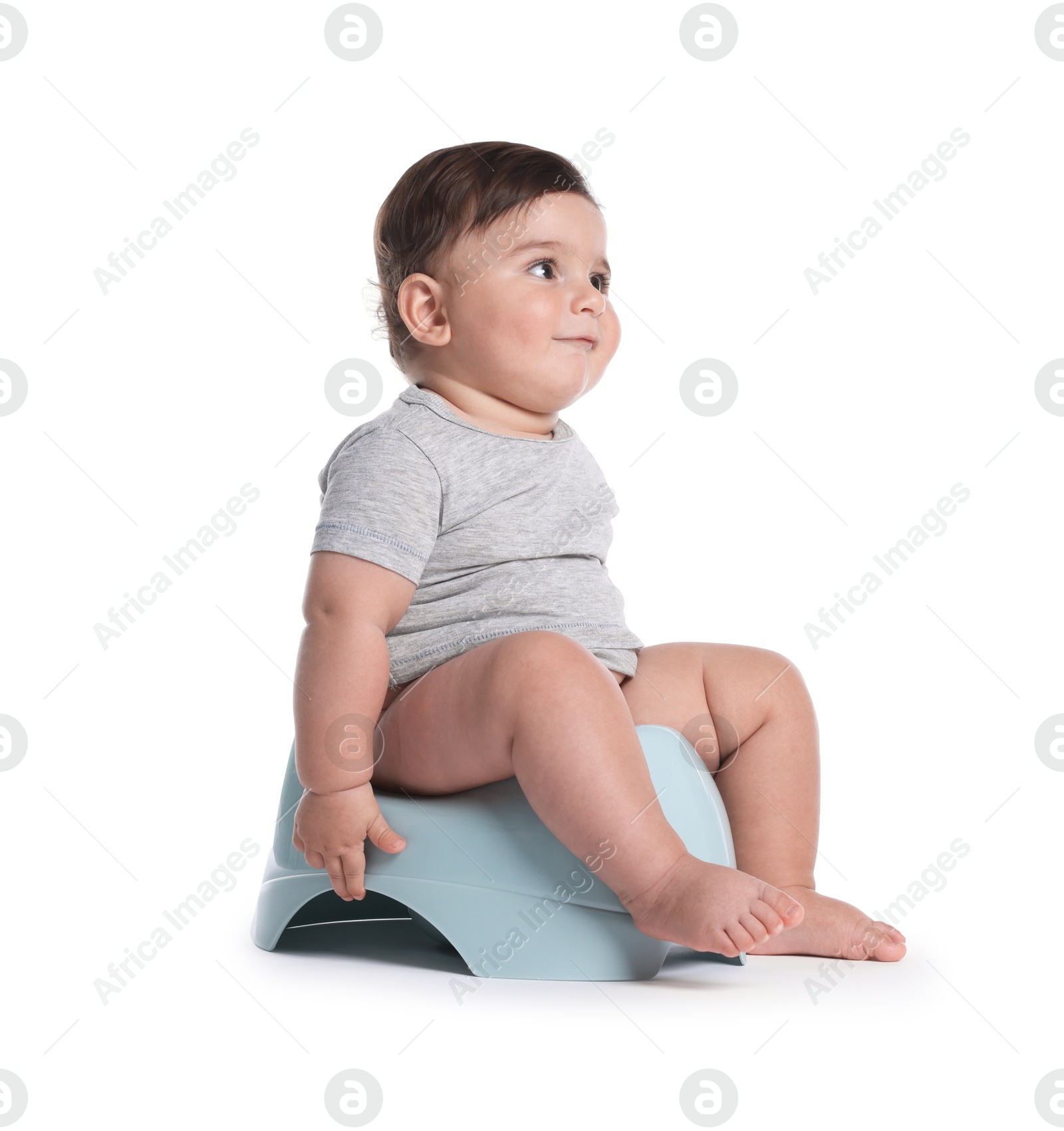 Cute little baby sitting on potty against white background Photo of Cute little baby sitting on potty against white background