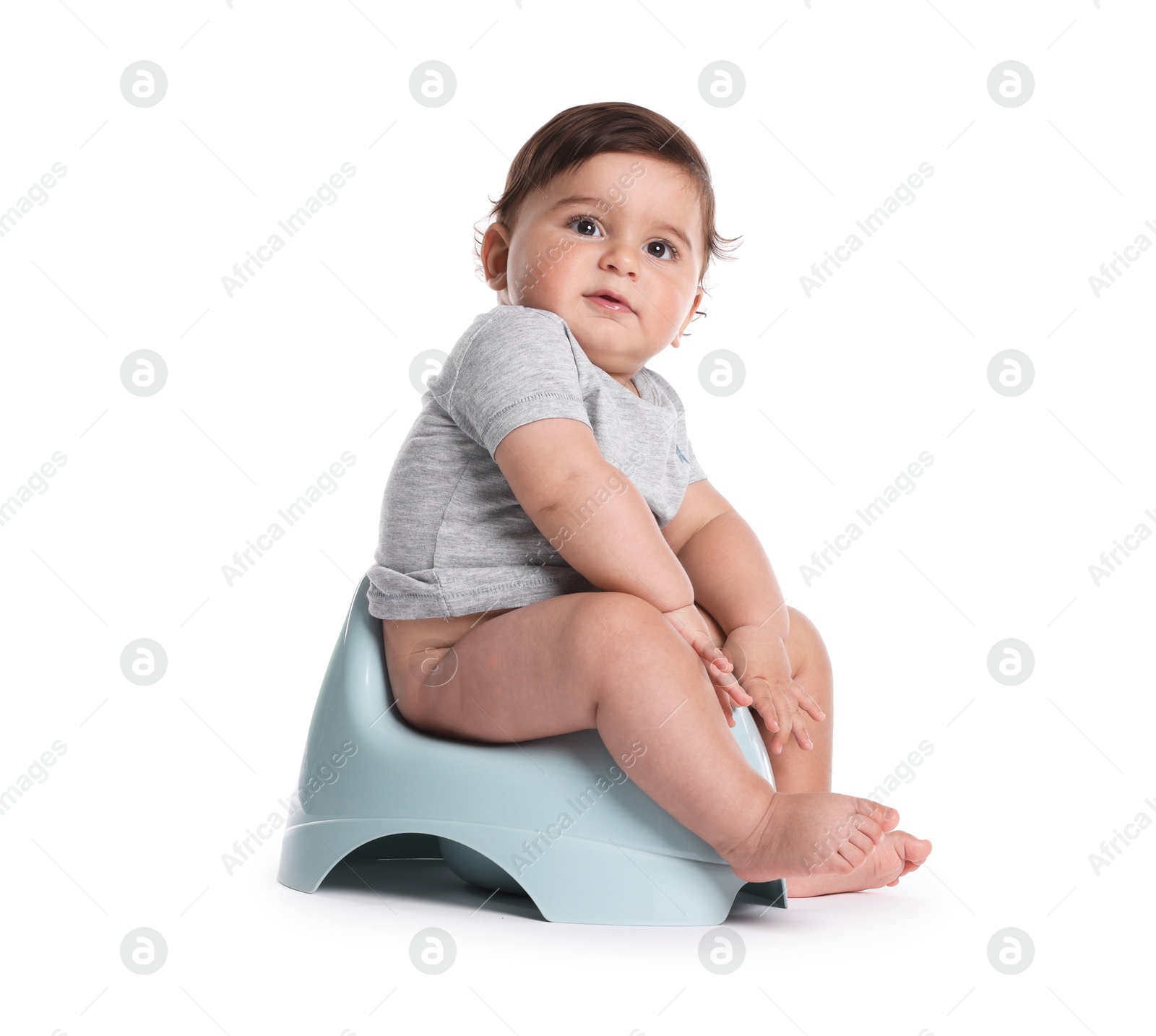 Cute little baby sitting on potty against white background Photo of Cute little baby sitting on potty against white background