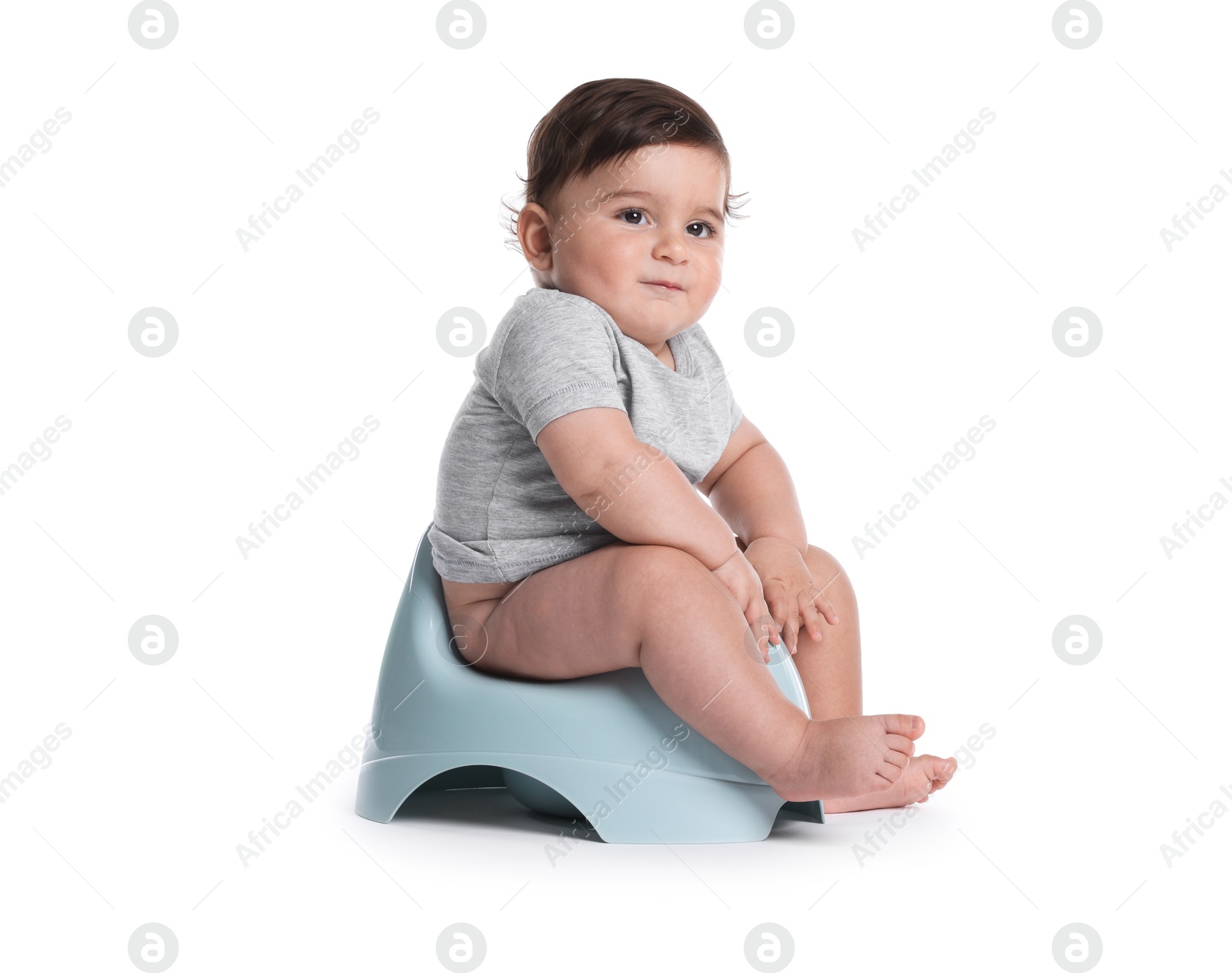Cute little baby sitting on potty against white background Photo of Cute little baby sitting on potty against white background