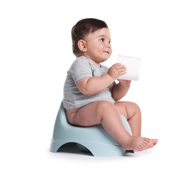 Photo of Cute little baby sitting on potty with toilet paper against white background