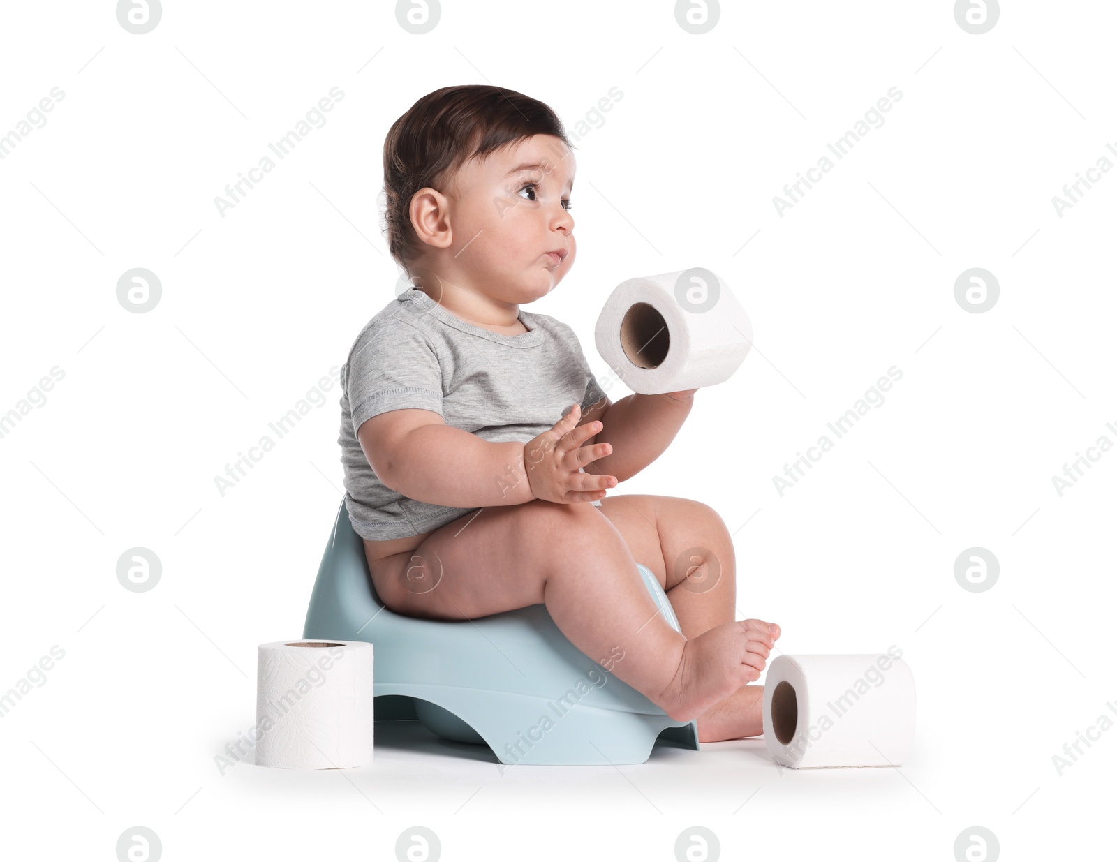 Cute little baby sitting on potty with toilet paper against white background Photo of Cute little baby sitting on potty with toilet paper against white background