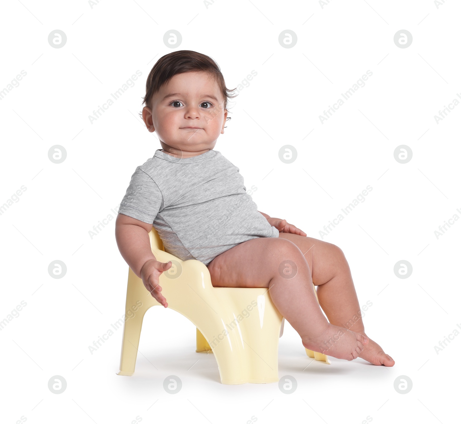 Cute little baby sitting on potty against white background Photo of Cute little baby sitting on potty against white background