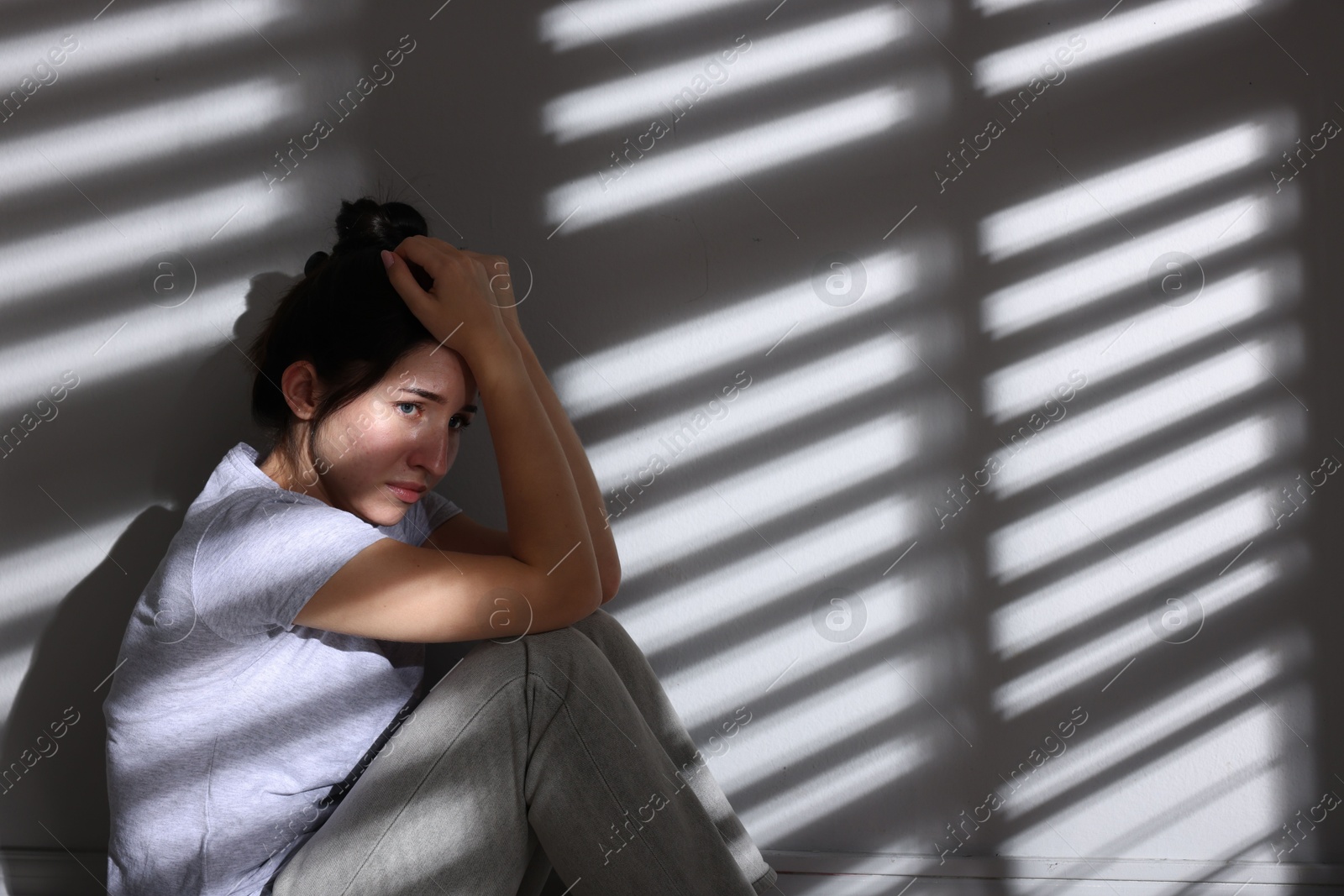 Emotional woman suffering from panic attack near wall indoors, space for text Photo of Emotional woman suffering from panic attack near wall indoors, space for text