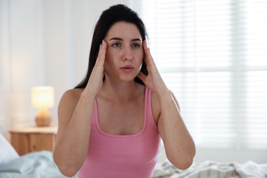 Photo of Panic attack. Woman calming herself down at home