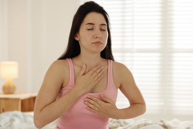 Photo of Panic attack. Woman breathing to calm down at home