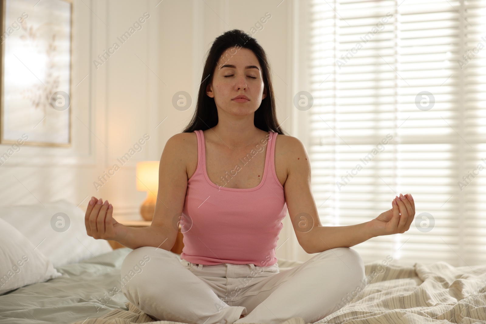 Panic attack. Woman meditating on bed indoors Photo of Panic attack. Woman meditating on bed indoors