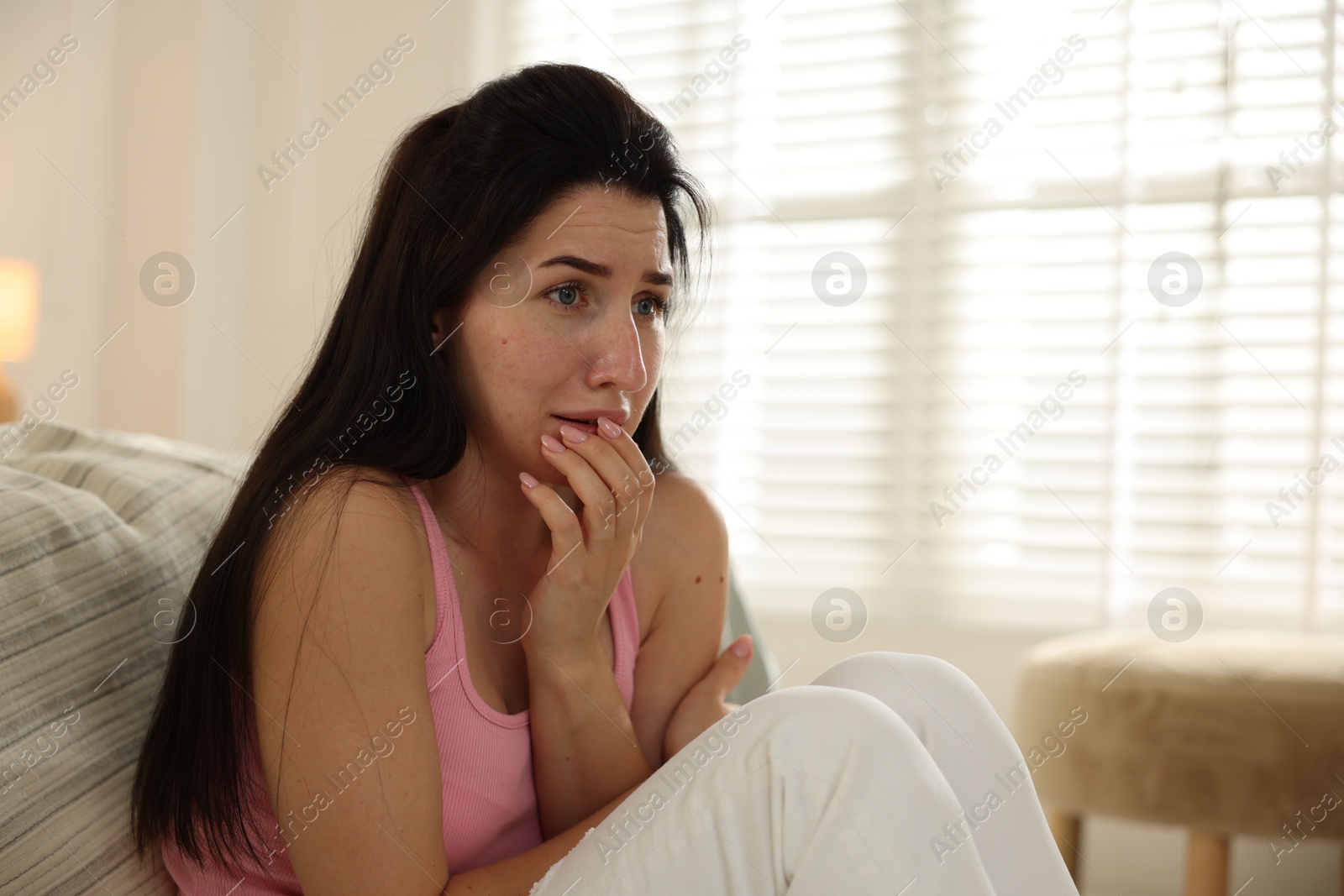 Emotional woman suffering from panic near bed indoors Photo of Emotional woman suffering from panic near bed indoors