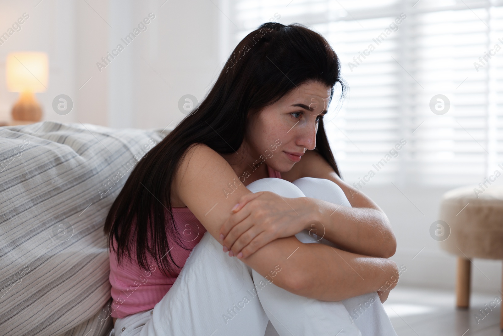 Emotional woman suffering from panic near bed indoors Photo of Emotional woman suffering from panic near bed indoors