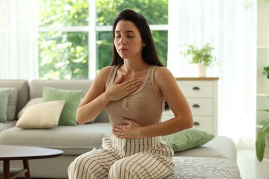 Photo of Panic attack. Woman breathing to calm down at home