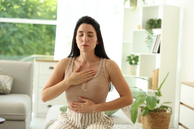 Photo of Panic attack. Woman breathing to calm down at home
