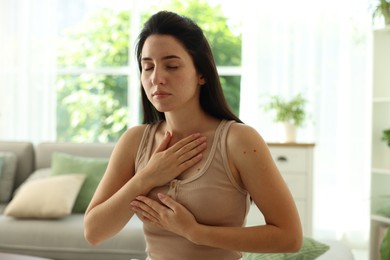 Photo of Panic attack. Woman breathing to calm down at home