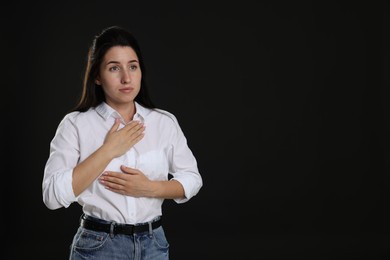 Photo of Panic attack. Woman breathing to calm down on black background, space for text