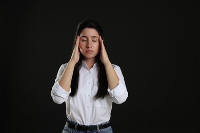 Photo of Panic attack. Woman calming herself down on black background