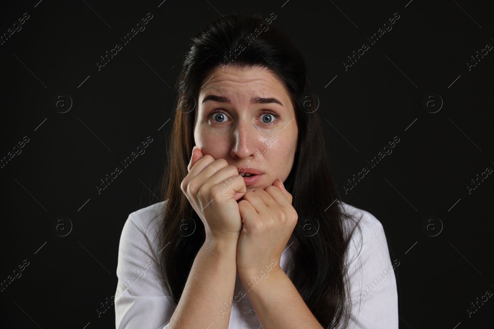 Woman suffering from panic attack on black background Photo of Woman suffering from panic attack on black background