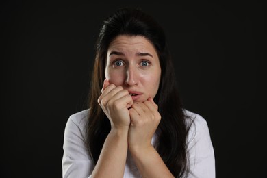 Photo of Woman suffering from panic attack on black background