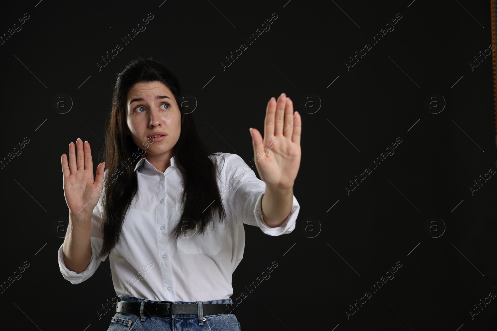 Woman suffering from panic attack on black background, space for text Photo of Woman suffering from panic attack on black background, space for text