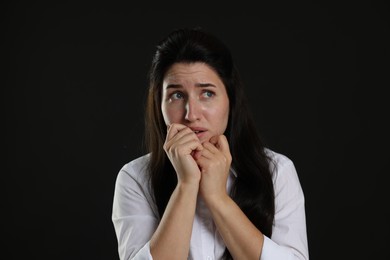 Photo of Woman suffering from panic attack on black background