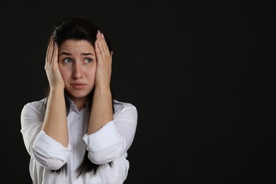 Photo of Woman suffering from panic attack on black background, space for text