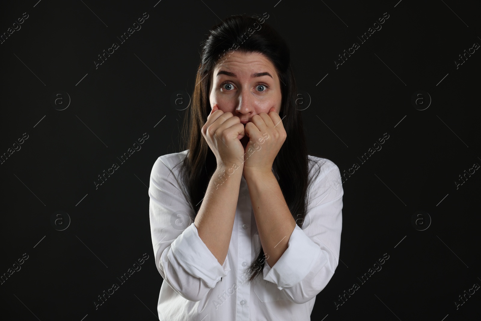 Photo of Woman suffering from panic attack on black background