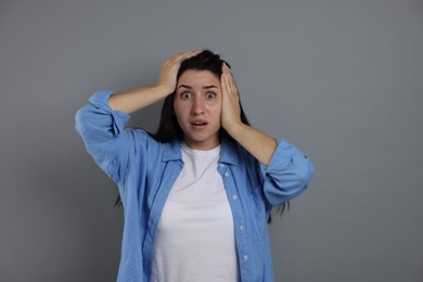 Photo of Woman suffering from panic attack on grey background