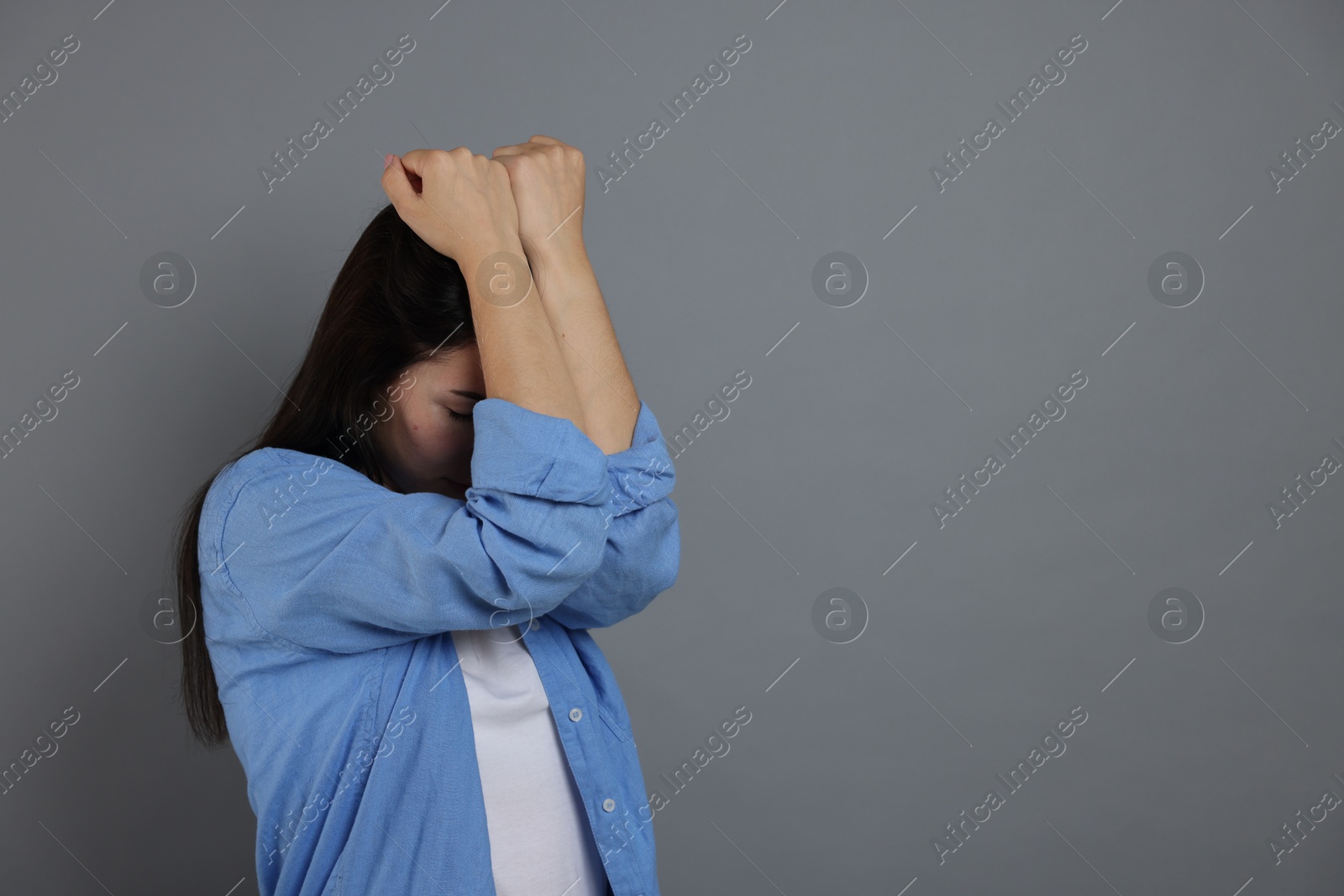 Woman suffering from panic attack on grey background, space for text Photo of Woman suffering from panic attack on grey background, space for text