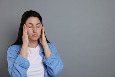 Photo of Panic attack. Woman calming herself down on grey background, space for text