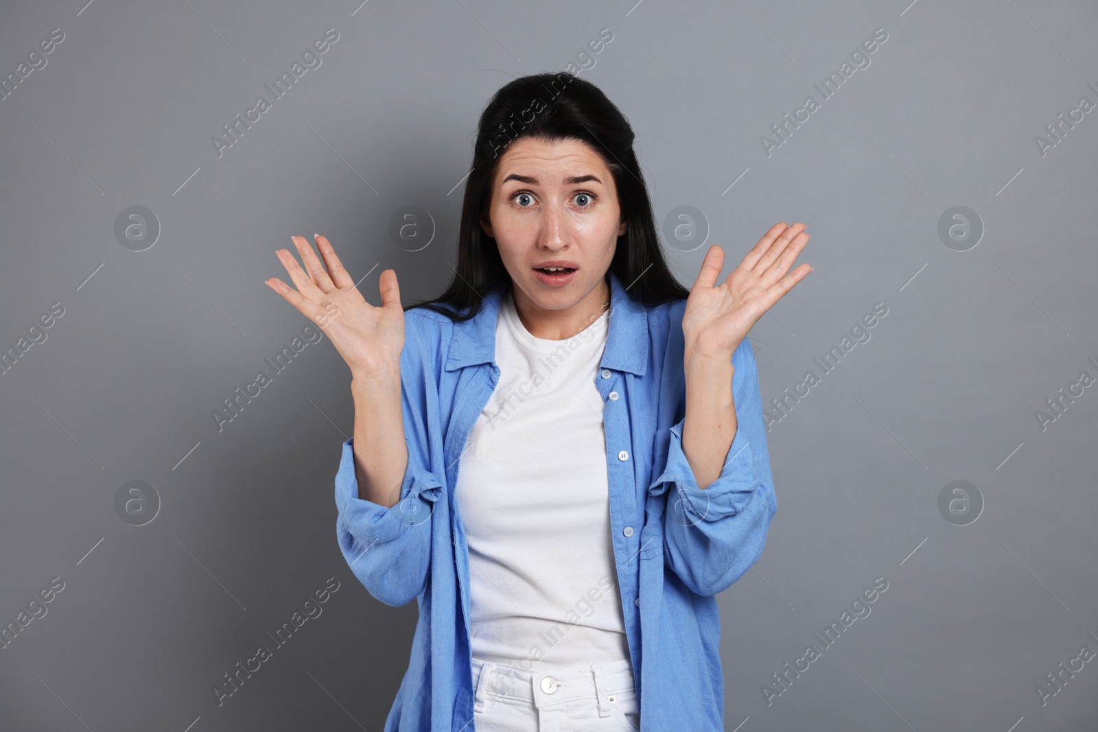 Woman suffering from panic attack on grey background Photo of Woman suffering from panic attack on grey background