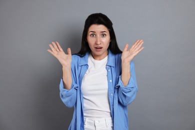 Photo of Woman suffering from panic attack on grey background