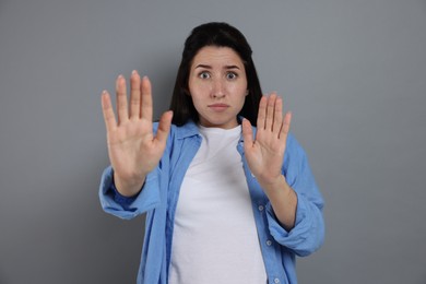 Photo of Woman suffering from panic attack on grey background