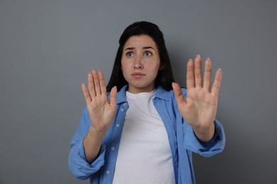 Photo of Woman suffering from panic attack on grey background