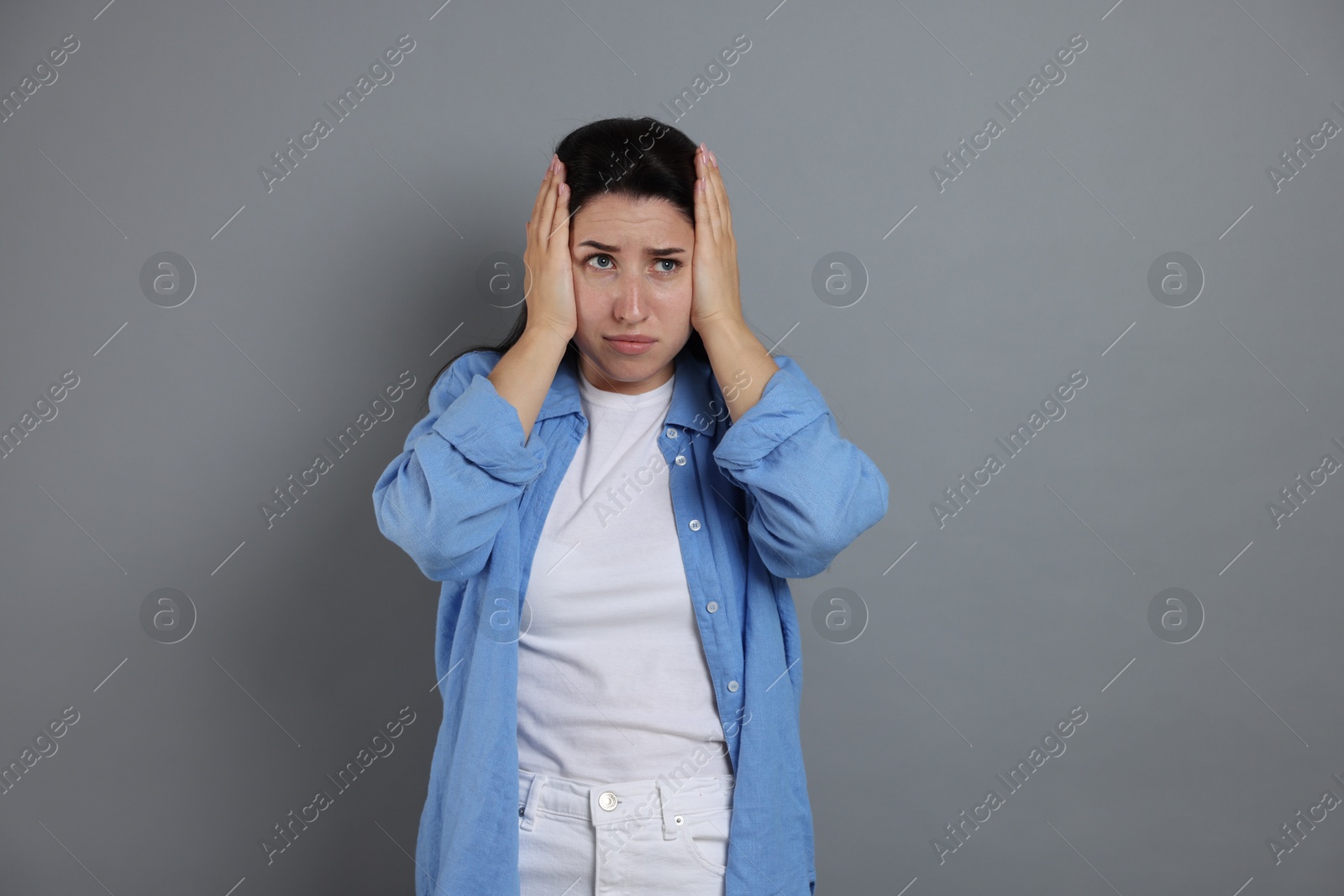 Woman suffering from panic attack on grey background Photo of Woman suffering from panic attack on grey background