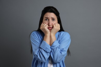 Photo of Woman suffering from panic attack on grey background
