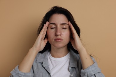 Photo of Panic attack. Woman calming herself down on beige background