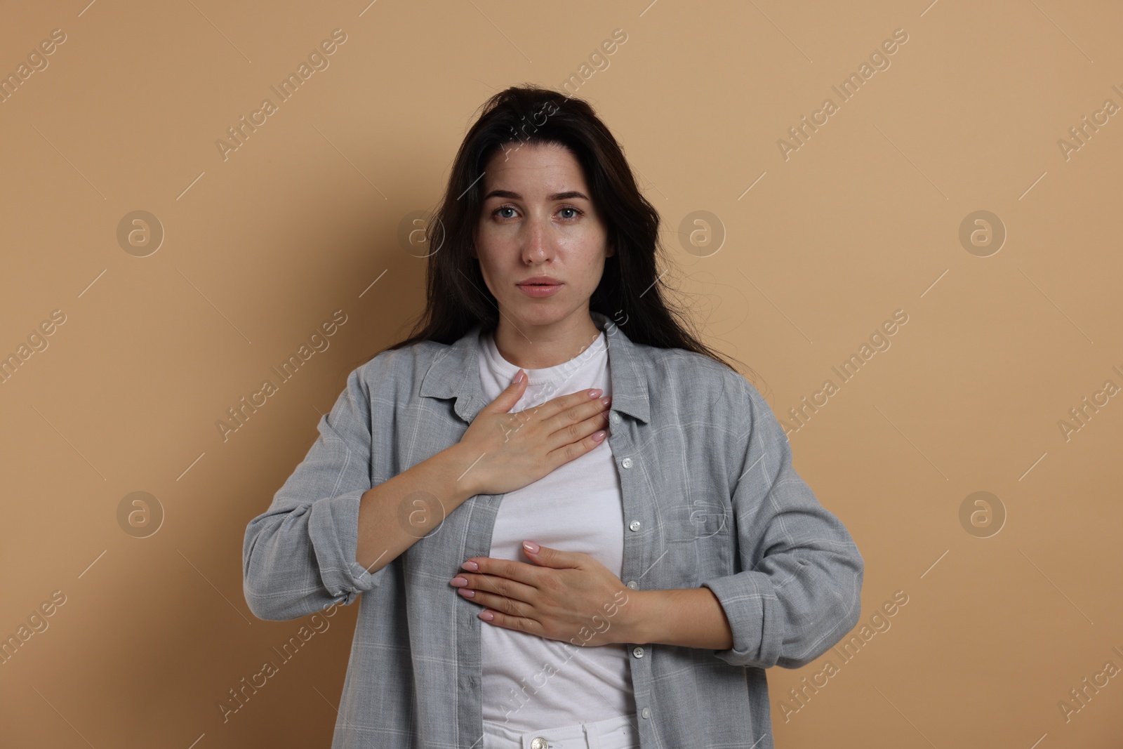Panic attack. Woman breathing to calm down on beige background Photo of Panic attack. Woman breathing to calm down on beige background
