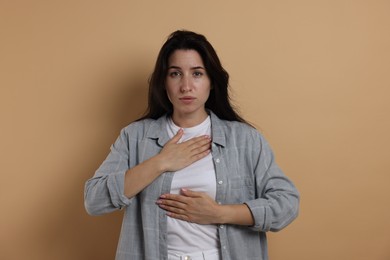 Photo of Panic attack. Woman breathing to calm down on beige background