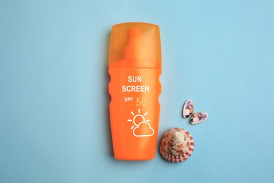 Image of Sunscreen in bottle and seashells on pastel blue background, top view. Sun protection product