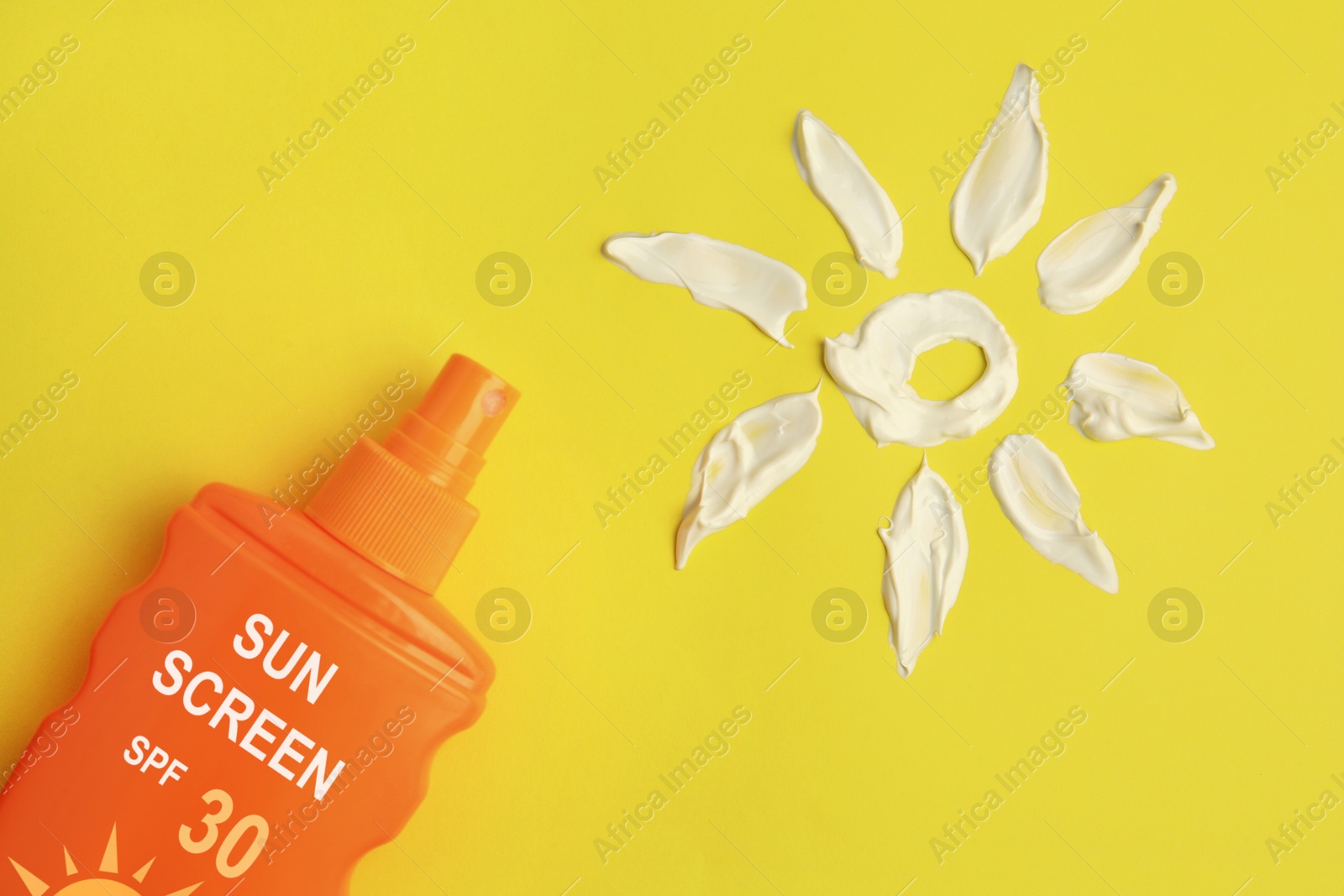 Sunscreen in bottle and sun made of sun protection cream on yellow background, top view Image of Sunscreen in bottle and sun made of sun protection cream on yellow background, top view