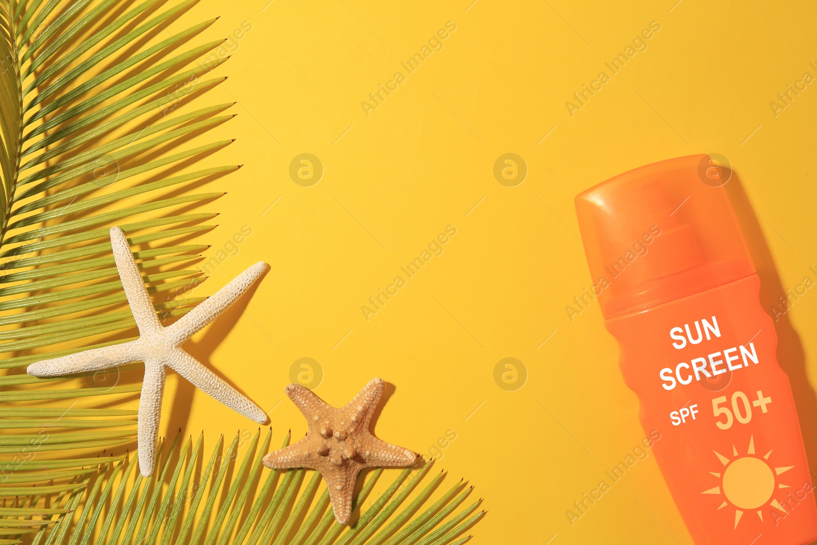 Sunscreen in bottle, sea stars and green palm leaves on orange background, top view. Sun protection product Image of Sunscreen in bottle, sea stars and green palm leaves on orange background, top view. Sun protection product