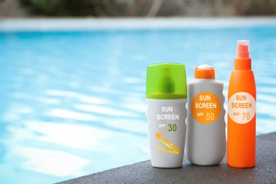 Image of Sunscreens in bottles on swimming pool edge. Sun protection product