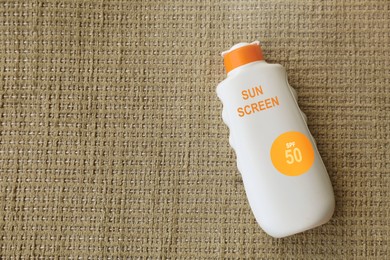 Image of Sunscreen in bottle on cloth, top view. Sun protection product