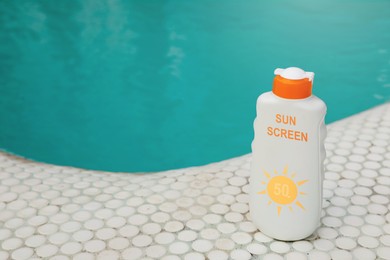 Image of Sunscreen in bottle on swimming pool edge. Sun protection product