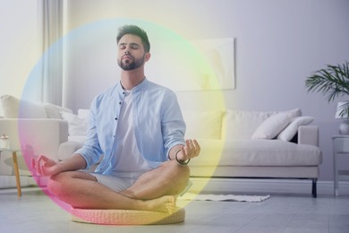 Image of Man meditating in Lotus pose at home. Rainbow bubble around him representing aura