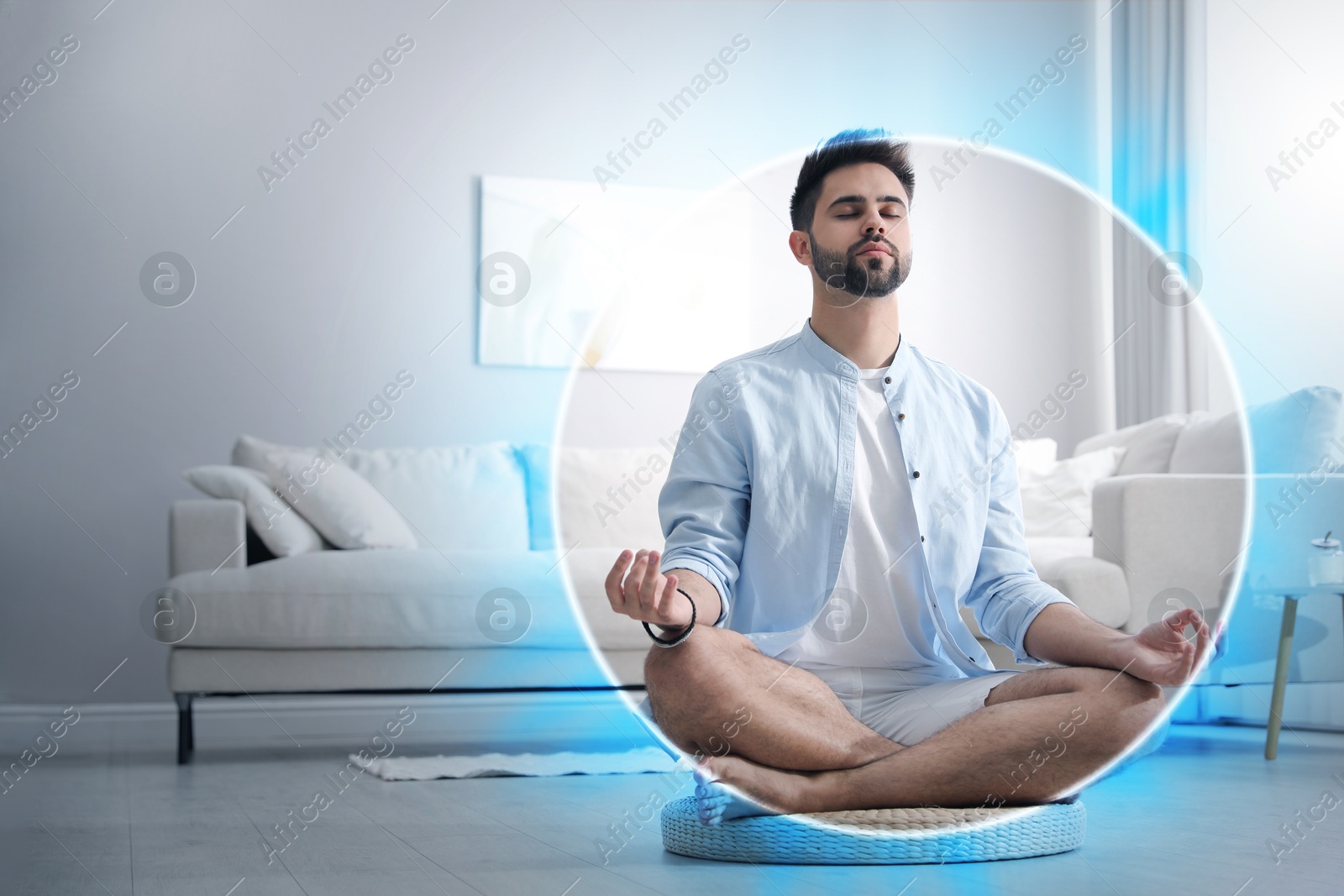 Man meditating in Lotus pose at home. Blue bubble around him representing aura Image of Man meditating in Lotus pose at home. Blue bubble around him representing aura