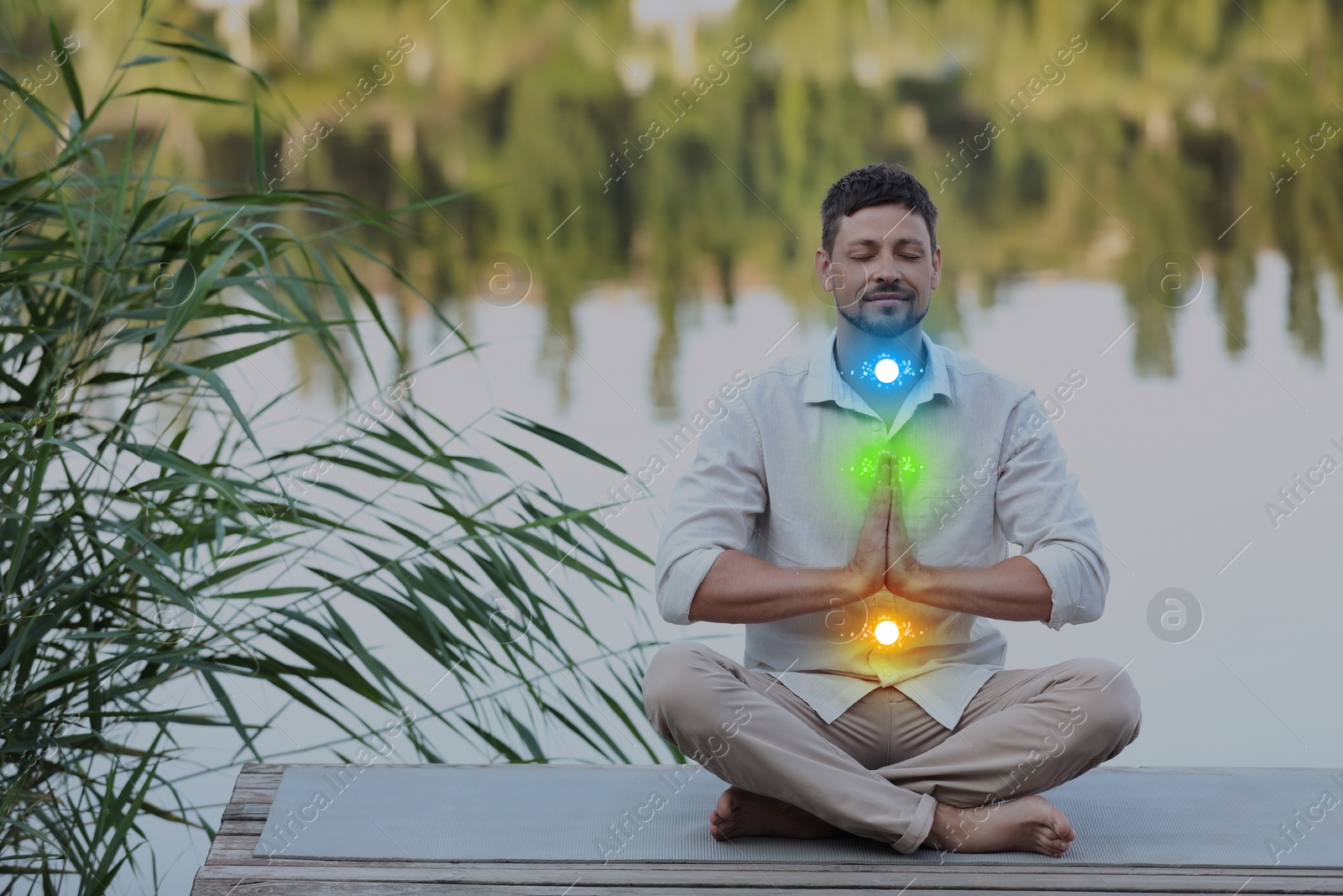 Man meditating in Lotus pose on pier near river. Glowing bubbles representing chakras Image of Man meditating in Lotus pose on pier near river. Glowing bubbles representing chakras