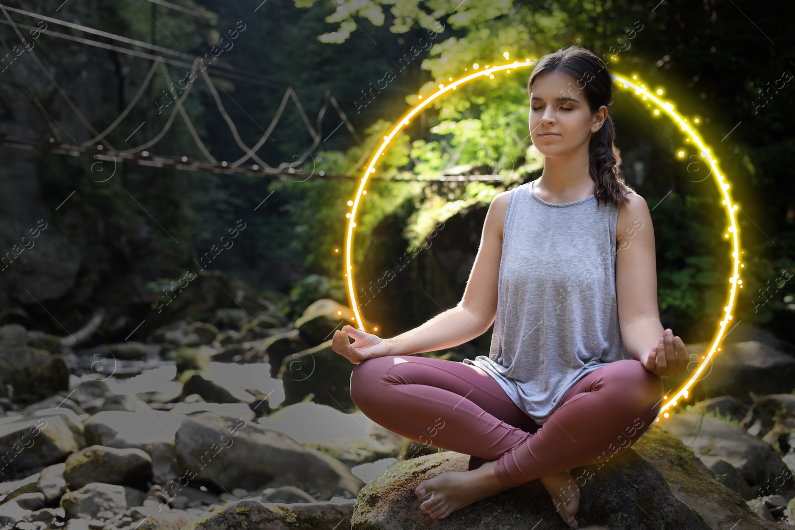 Image of Woman meditating in Lotus pose in mountains. Bright bubble around her representing aura