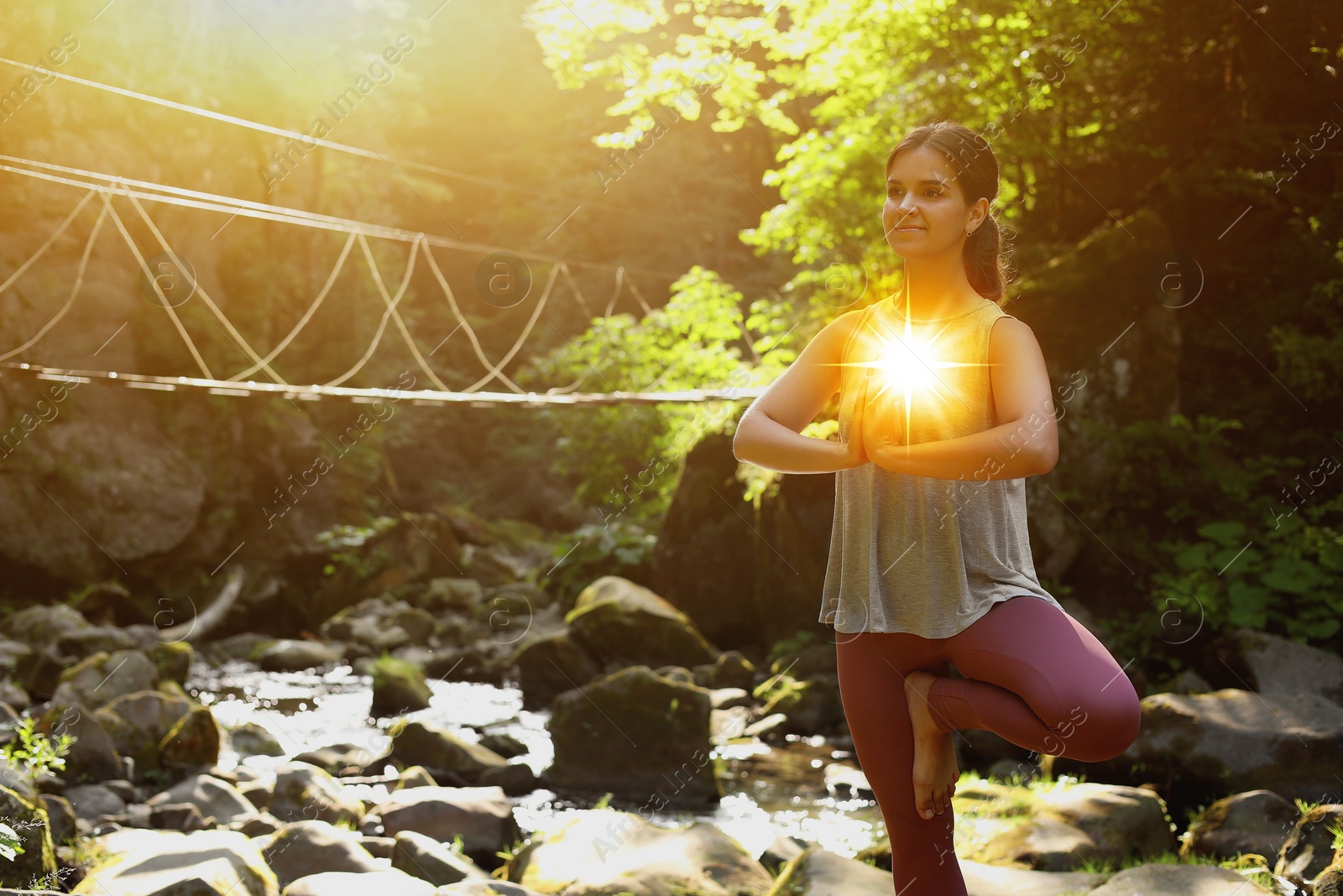 Woman meditating in Tree pose in mountains. Glowing bubble representing chakra Image of Woman meditating in Tree pose in mountains. Glowing bubble representing chakra