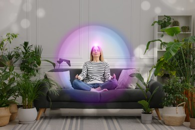 Image of Woman meditating in Lotus pose at home. Bright bubble around her representing aura