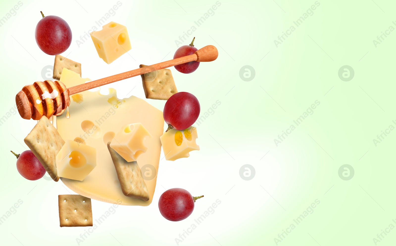 Cheese, grapes, crackers and honey in air on light green gradient background. Tasty appetizers for cheese board Image of Cheese, grapes, crackers and honey in air on light green gradient background. Tasty appetizers for cheese board